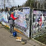 Начали зачищать от старой краски забор в Городском парке