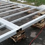 Установка металлической конструкции на деревянные дощечки в городском парке