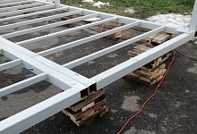 Установка металлической конструкции на деревянные дощечки в городском парке