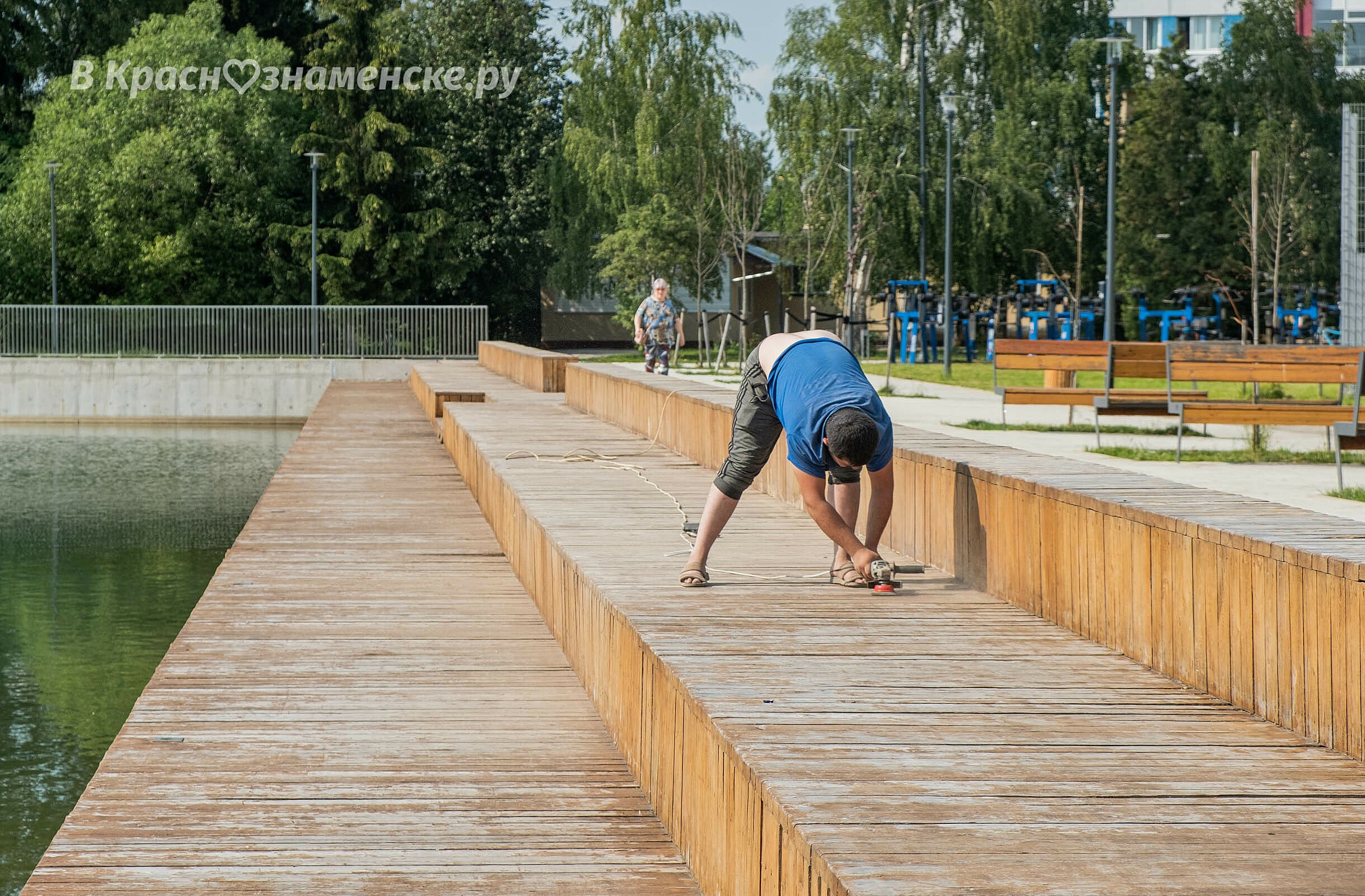 Шлифовка деревянного настила на городском озере.  В скором в